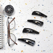 Matt black Metal Tic Tac Hair Clips on a neutral background, showcasing their sleek design.